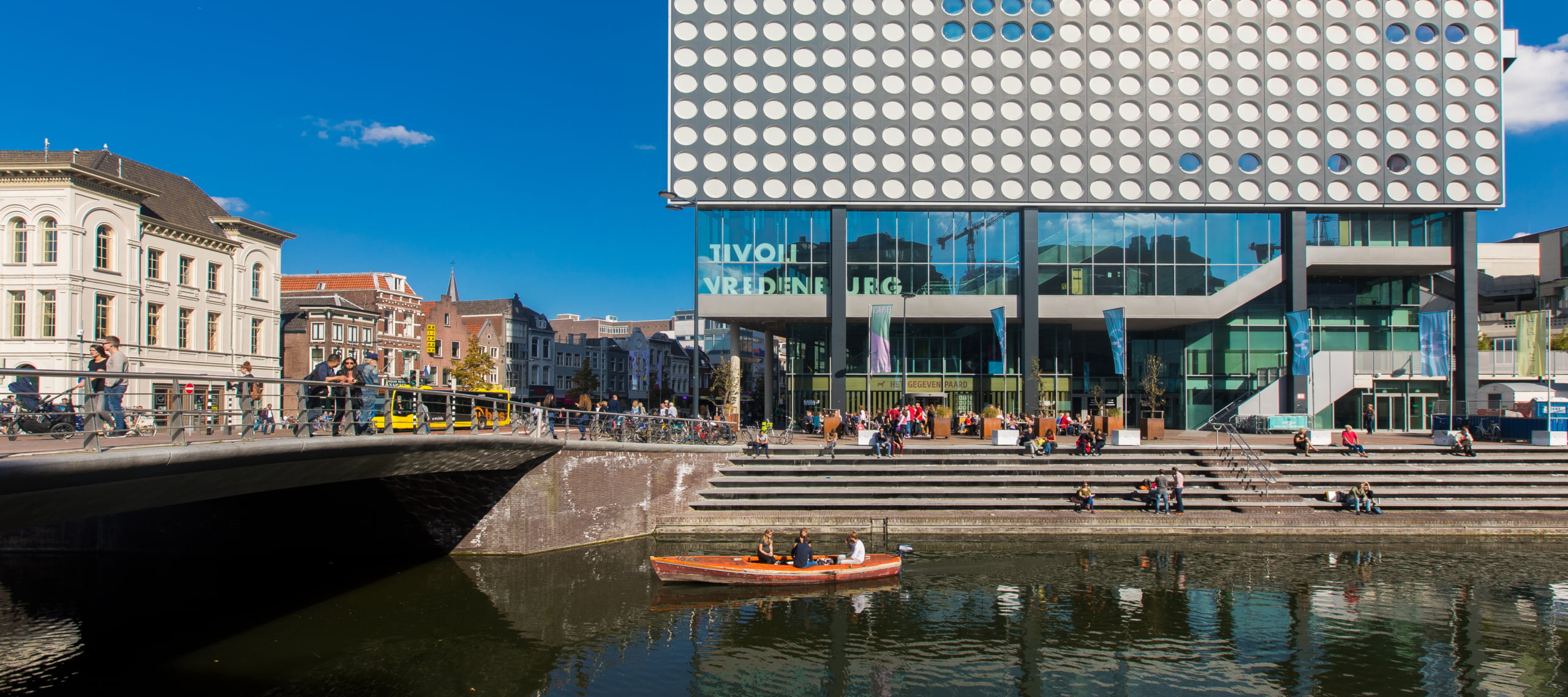 singel van Utrecht met een kano erin, op de achtergrond staat het gebouw van Tivoli Vredenburg en het centrum van Utrecht.