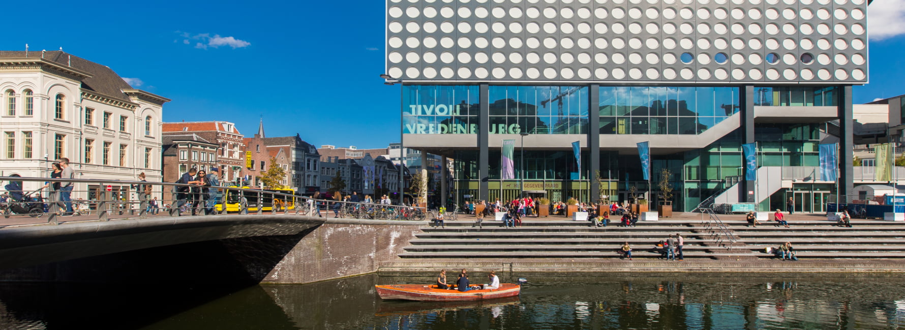 singel van Utrecht met een kano erin, op de achtergrond staat het gebouw van Tivoli Vredenburg en het centrum van Utrecht.