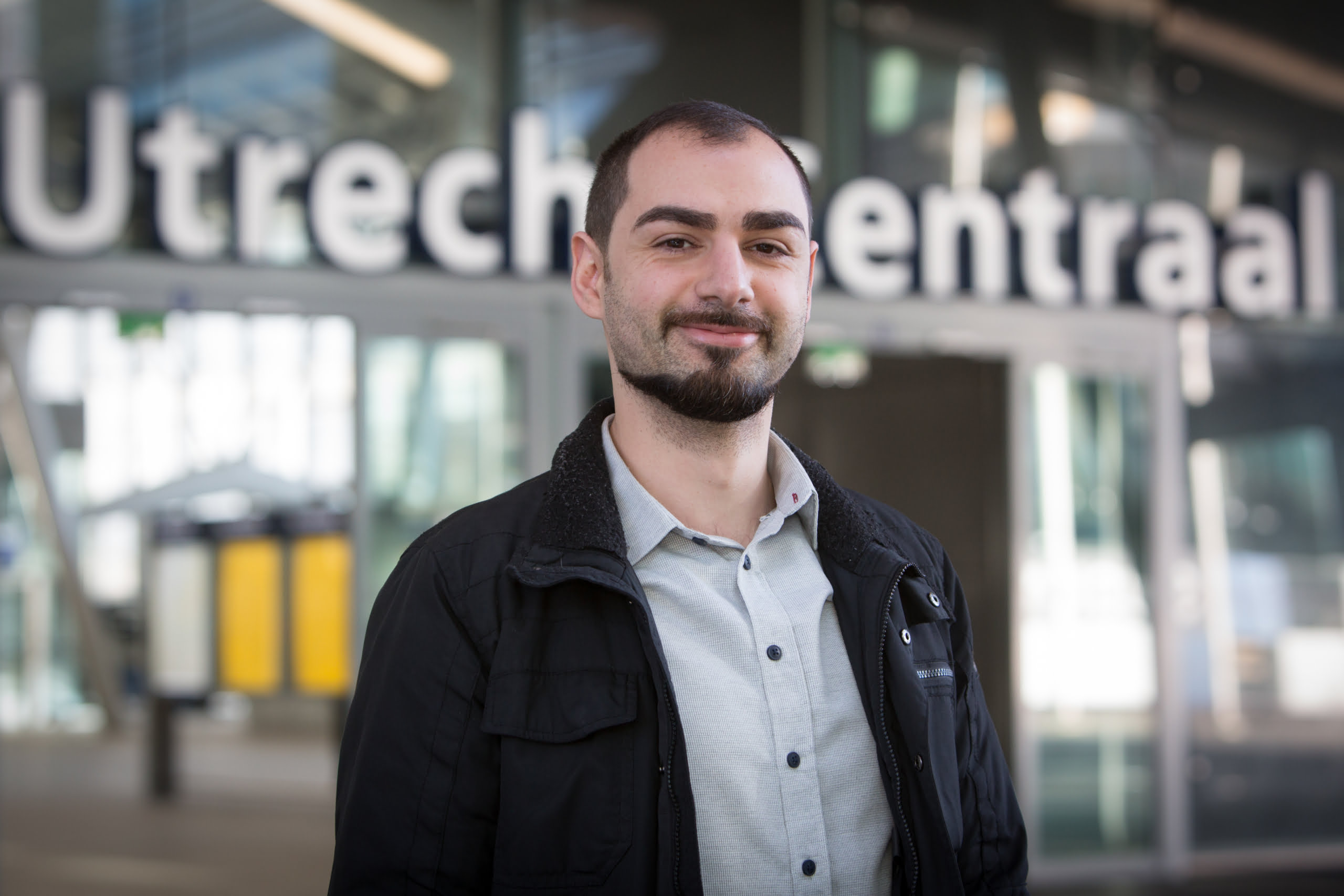 een mannelijke collega met op de achtergrond de ingang van statio Utrecht centraal