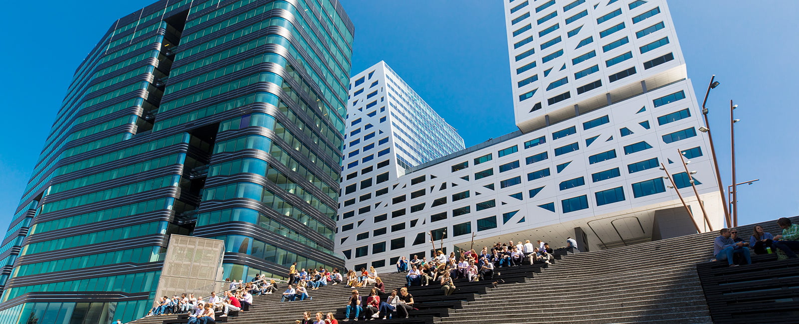 Het stadskantoor en een ander kantoorpand van onderen gezien bij de trappen op het Jaarbeursplein.