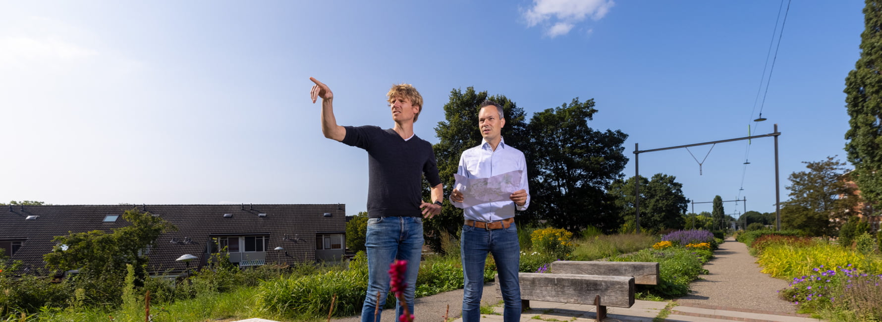 René en Dion, landschapcarchtecten kijken samen in park naar een plan