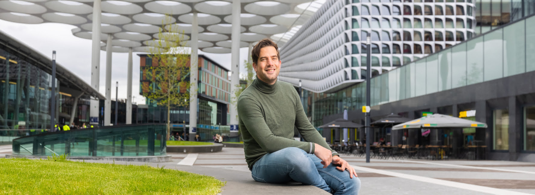 Business controller Daniel zot op bankje buiten onder bollendak