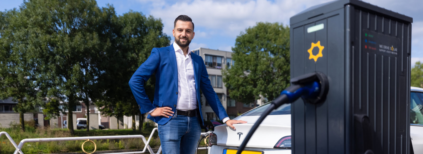 Projectmanager staat bij een elektrische auto voor een laadpaal