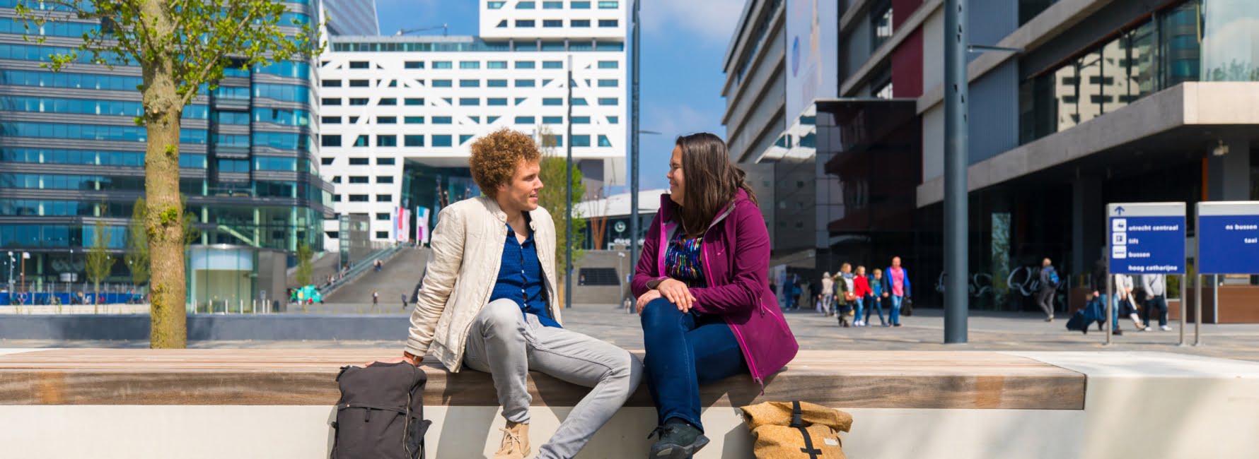 Twee medewerkers zitten op een bankje op het Jaarbeursplein