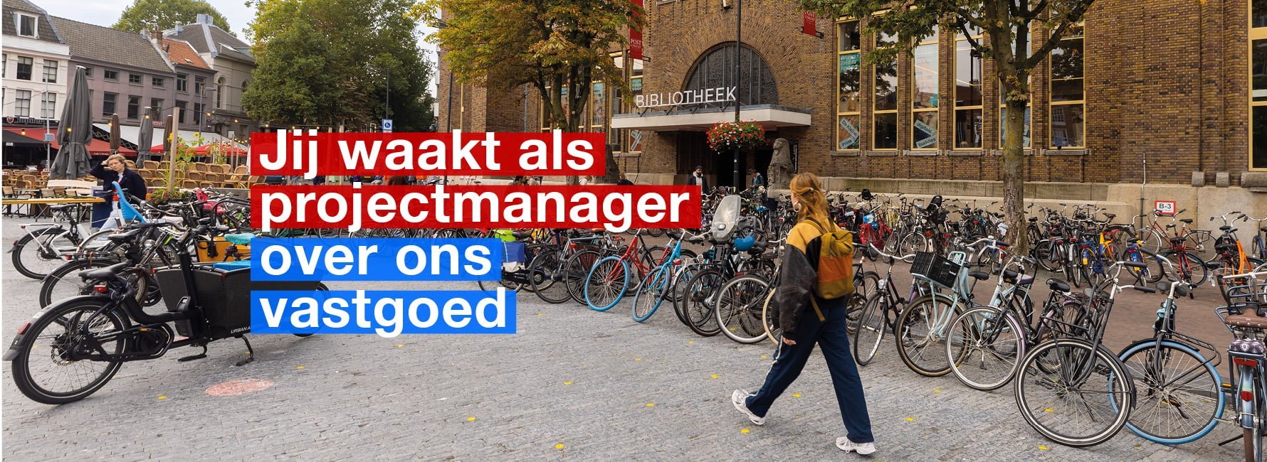 Vrouw wandelt over Neude langs de gevel van de bibliotheek
