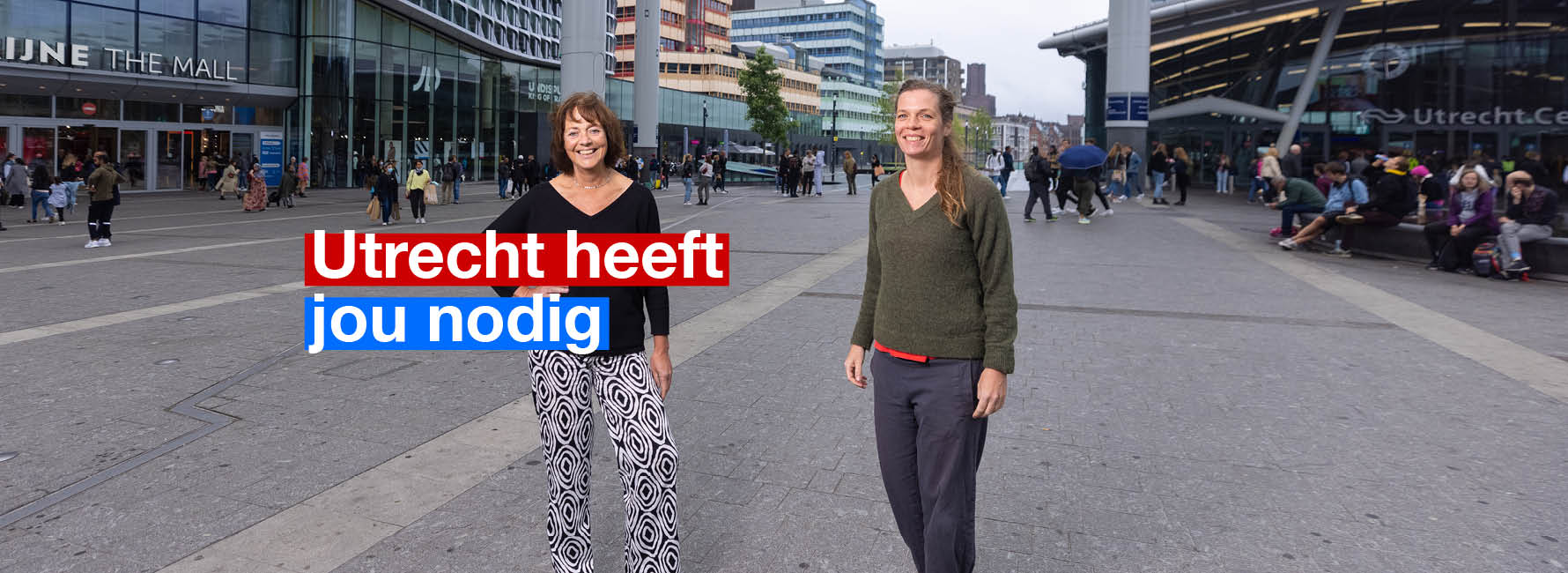 Twee vrouwen op het stationsplein. In beeld staat de tekst Utrecht heeft jou nodig.