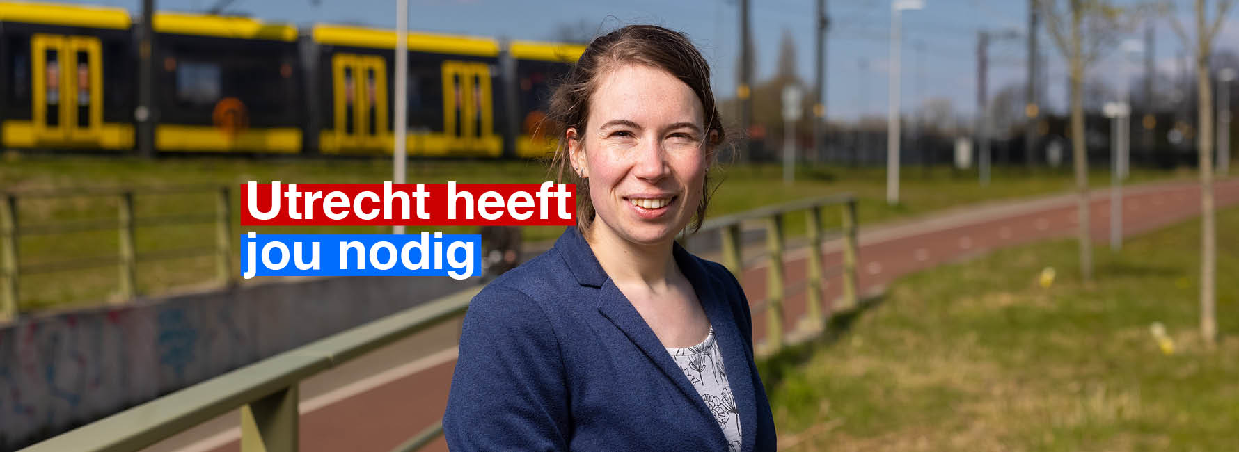 Iemand staat voor een trambaan met op de achtergrond een tram. In beeld staat de tekst Utrecht heeft jou nodig.