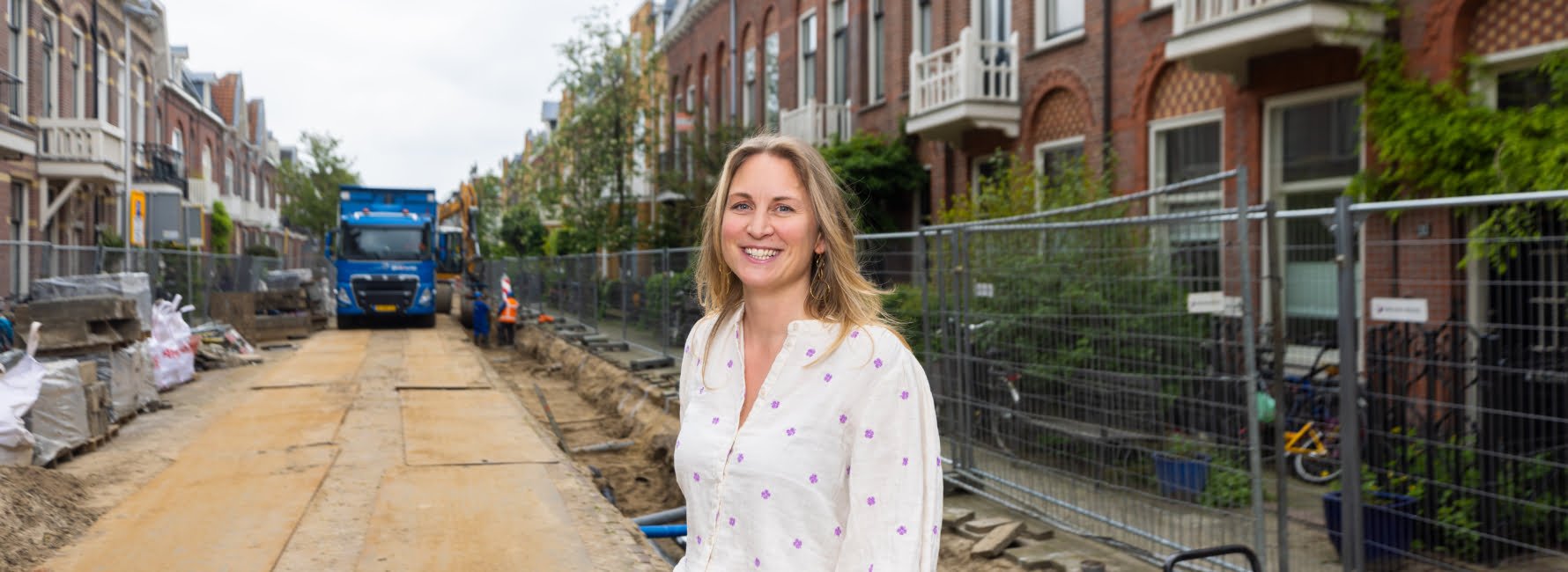 Een vrouw in een straat waar wordt gewerkt aan een aardgasvrije straat.