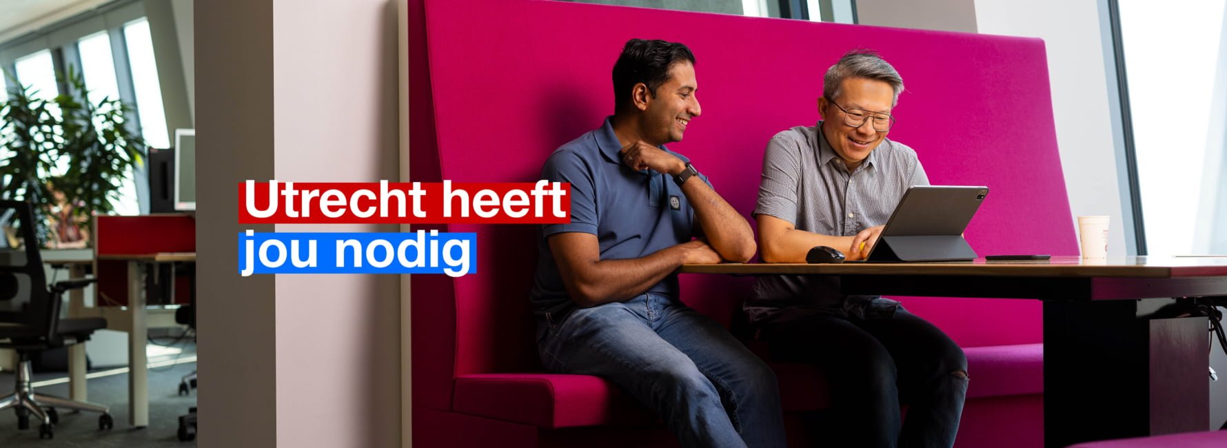 Twee collega's werken samen in het stadskantoor. In beeld staat de tekst: Utrecht heeft jou nodig.