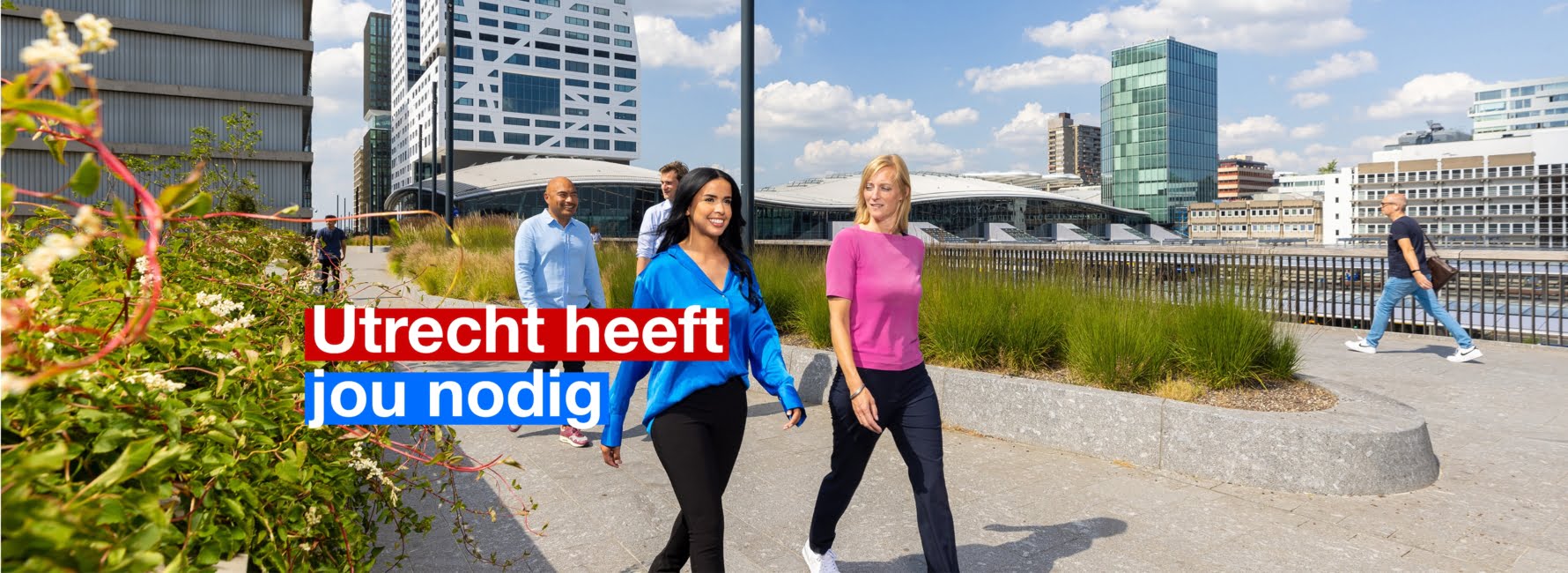 Vier collega's wandelen over de moreelsebrug, met op de achtergrond het stadskantoor en Utrecht Centraal Station. In beeld staat de tekst Utrecht heeft jou nodig.