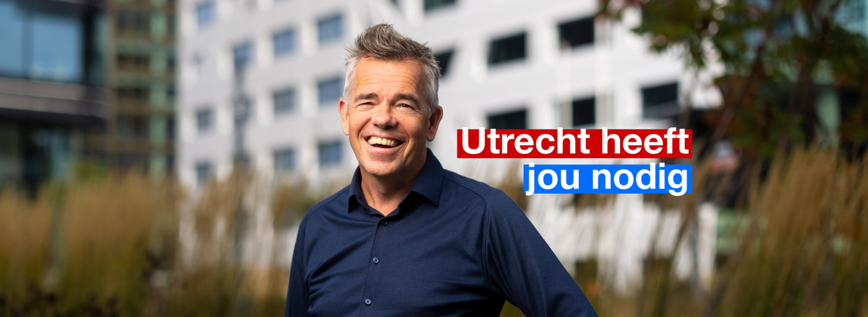 Een collega met op de achtergrond het stadskantoor. In beeld staat de tekst Utrecht heeft jou nodig.