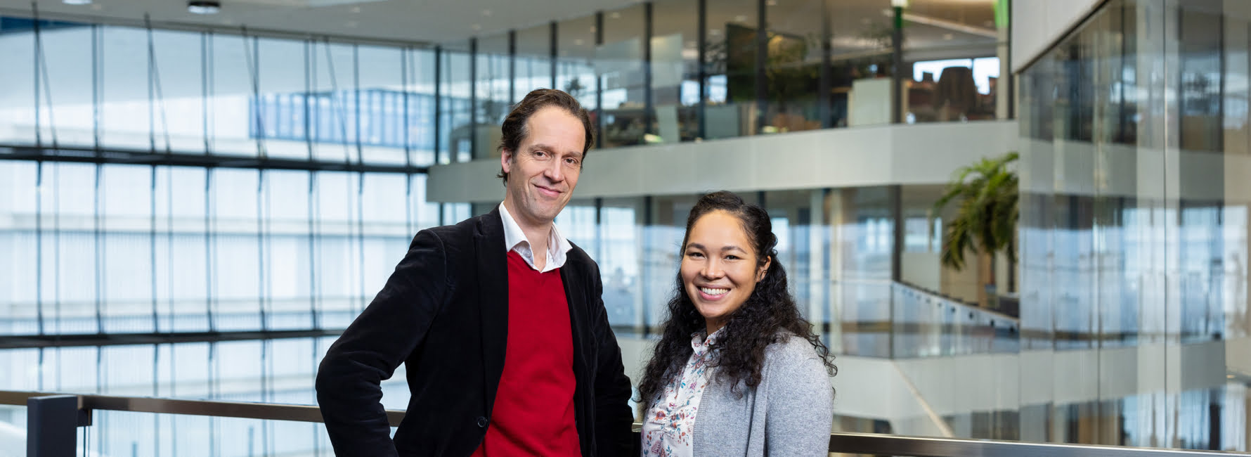 Twee medewerkers staan in het Stadskantoor van de gemeente Utrecht.