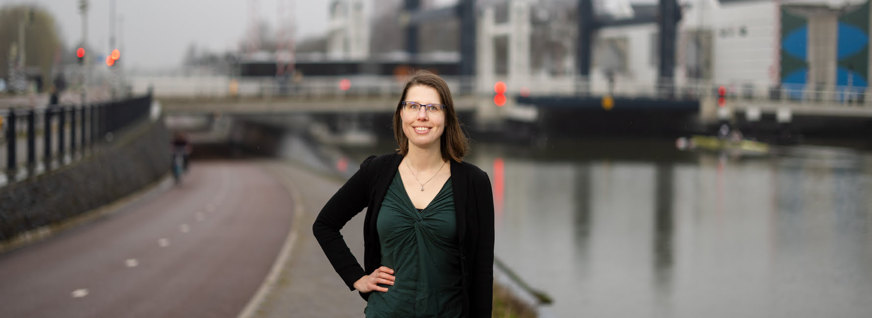 Technisch Adviseur staat langs het water voor de Nelson Mandelabrug