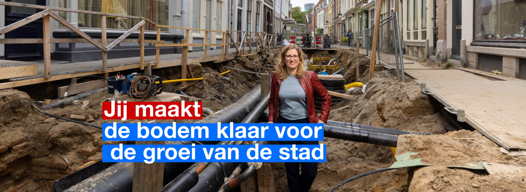 Technisch adviseur bodem en ondergrond staat in de opengebroken grond met leidingen afkomstig uit de ondergrond.