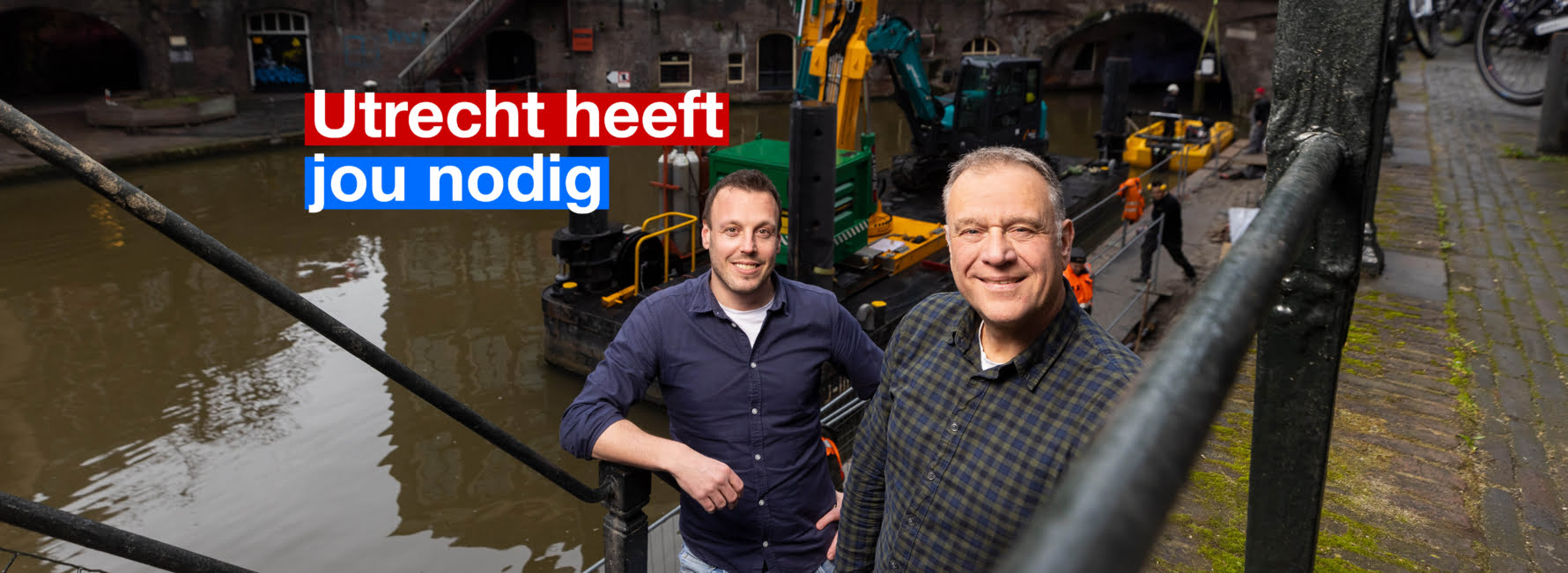 Twee Technisch adviseurs staan op de trap richting een werfkelder in Utrecht langs de Oudegracht. Deze werfkelder en de kade worden gerenoveerd.