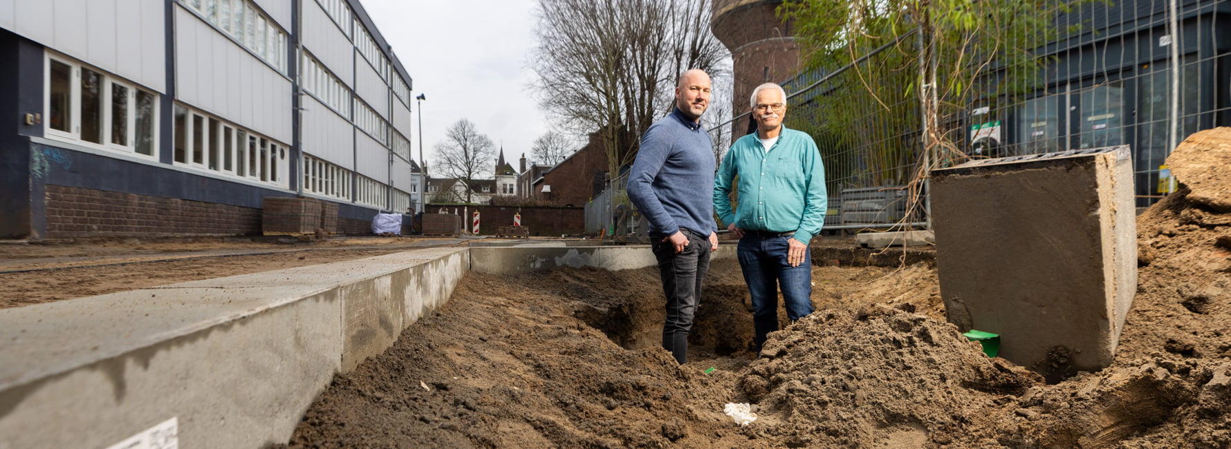 Twee technisch adviseurs staan in de opengebroken grond voor de watertoren bij Rotsoord, Utrecht.