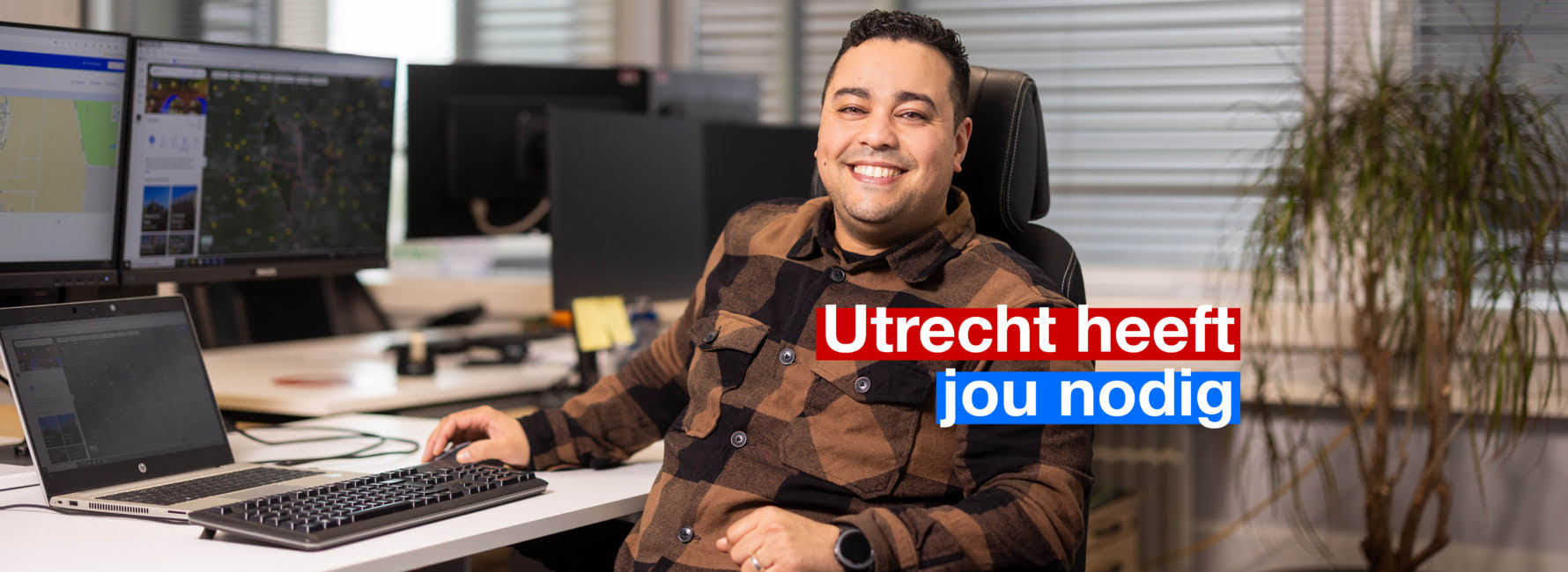 Een vrolijke medewerker van de afvalvoorziening die achter zijn bureau aan het werk is.