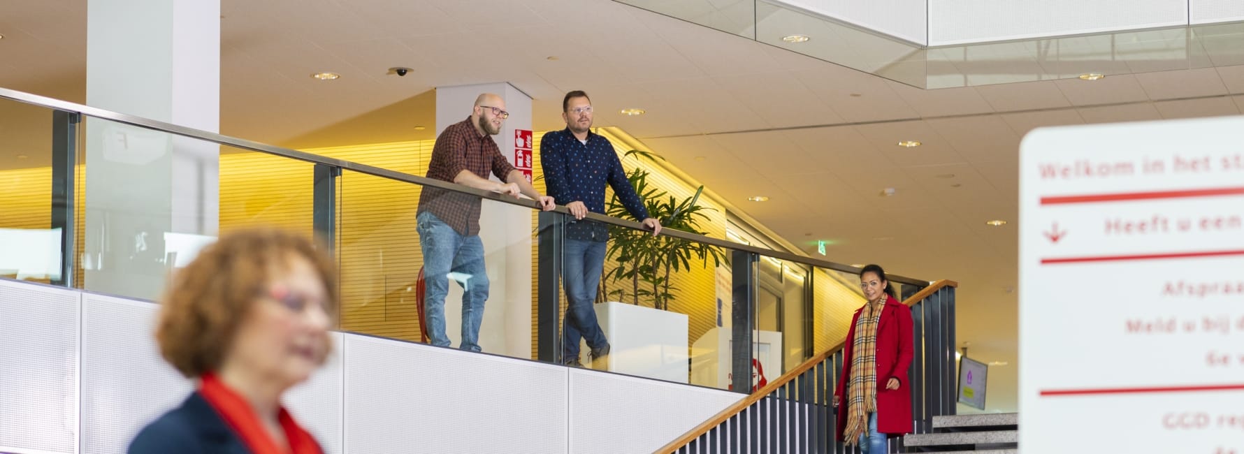 Twee medewerkers staan boven aan de trap bij het stadskantoor in Utrecht