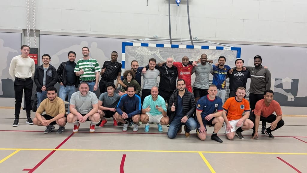 Groepsfoto van collega's die zaalvoetbal doen bij de gemeente