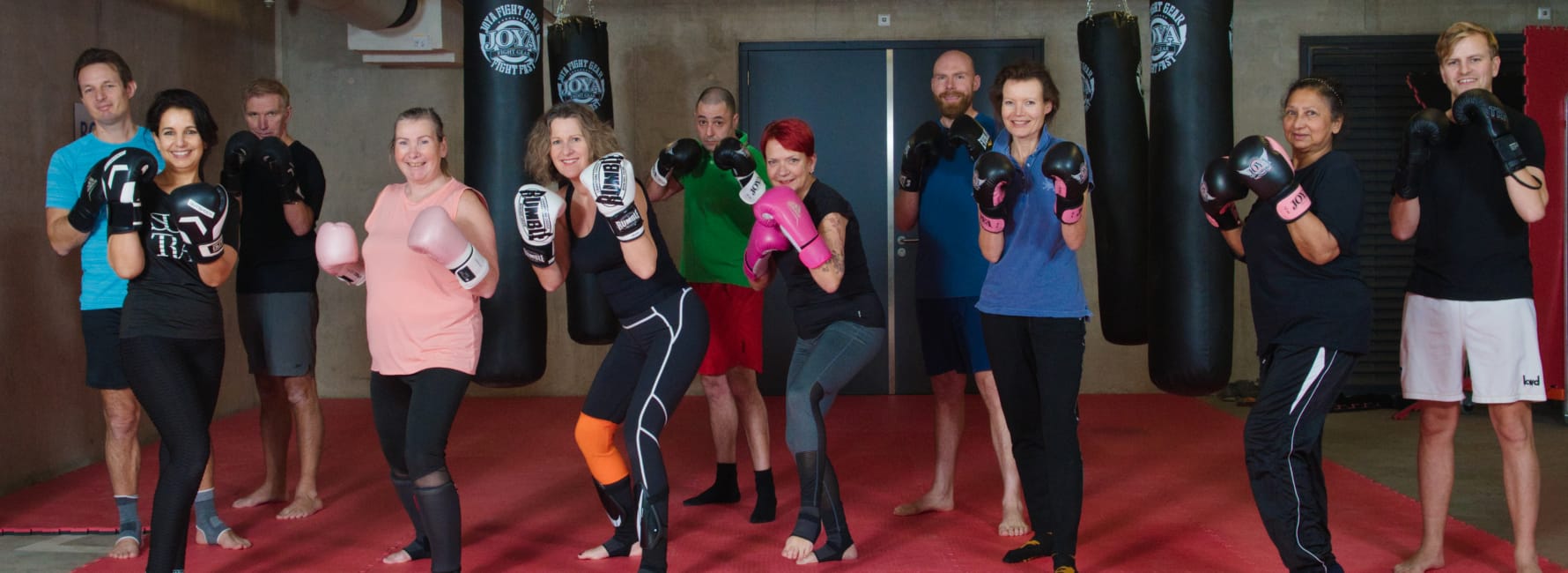 Collega's zijn samen aan het boksen op kantoor en hebben bokshandschoenen aan.