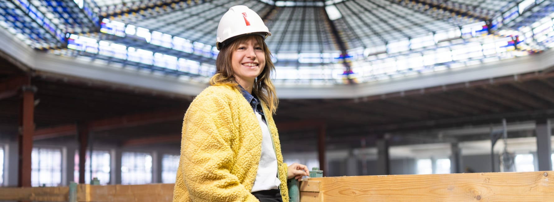 Projectleider Eva met bouwvakkershelm staat in Magazijn de Zon
