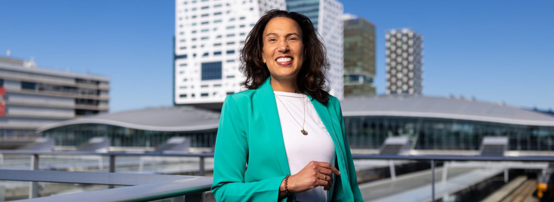 Omgevingsmanager Marjolein staat op de Moreelsebrug met in de achtergrond het stadskantoor