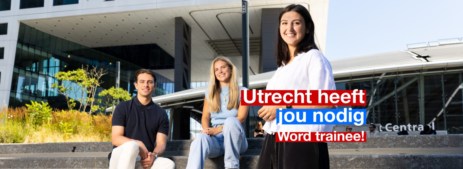 Drie medewerkers staan samen voor het stadskantoor Utrecht, met de tekst 'Word Trainee'